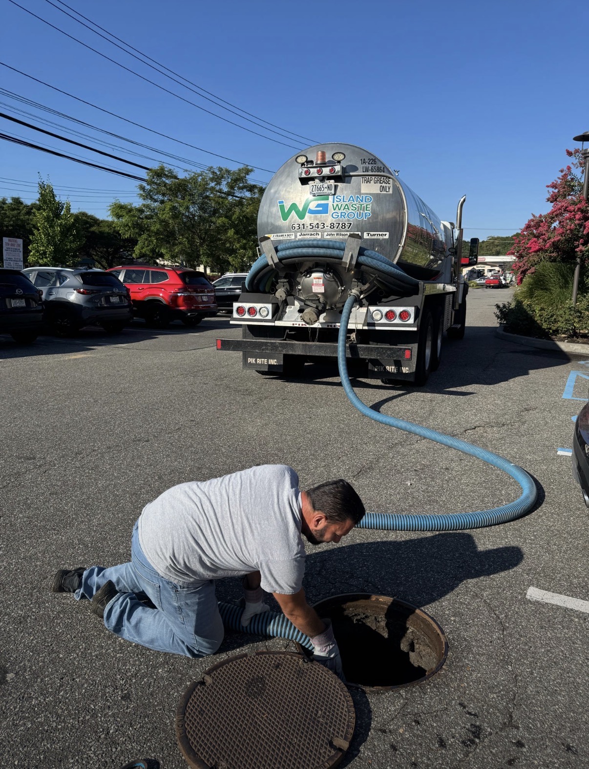 Island Waste Group grease service truck at an active commercial site