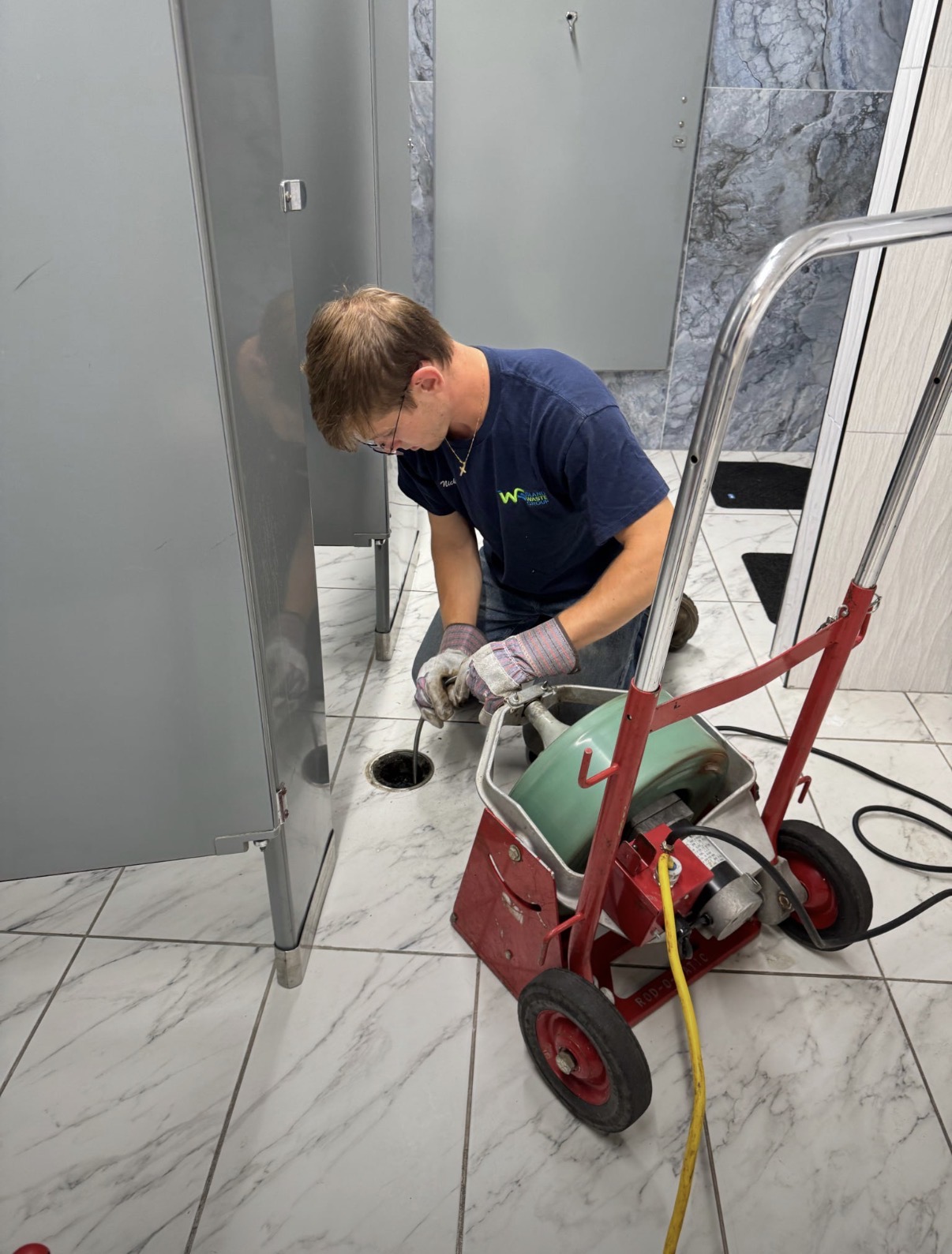 Island Waste Group technician using drain-cleaning equipment